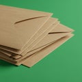 A stack of brown kraft paper envelopes positioned on a solid green background. The Royalty Free Stock Photo