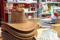 A stack of brown and white cowboy hats sitting on a table in a store.. The cowboy hat is a representation the the Western american