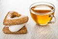 Stack of gingerbreads different shape, transparent cup with tea on wooden table