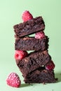 Stack of brownies and frozen raspberries. Dark chocolate dessert