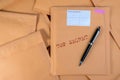 Stack of bubble wrap padded mailing envelopes and pen on white b