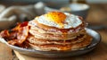 A stack of buckwheat flour pancakes served with a side of crispy bacon and eggs sunny side up Royalty Free Stock Photo