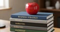 Stack of business books topped with a red apple symbolizing know Royalty Free Stock Photo