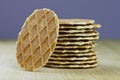 A stack of butter waffle cookies standing on a light wooden table over grey concrete background selective focus. Waffle crisps Royalty Free Stock Photo