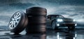 Stack of car wheels and tires with car in the rain Royalty Free Stock Photo