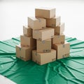 A stack of cardboard boxes arranged in a pyramid-like formation on a green fabric Royalty Free Stock Photo