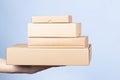 Stack of cardboard boxes in female hands. Blank brown parcel boxes on light blue background. Packaging, shopping, free Royalty Free Stock Photo