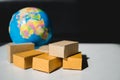 Stack cardboard boxes with mini globe background Royalty Free Stock Photo