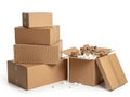 Stack of cardboard boxes with one open box showing packing material isolated on white background Royalty Free Stock Photo