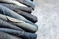 A stack of carelessly folded jeans on gray background. Close-up of jeans in different colors. Denim background Royalty Free Stock Photo