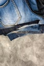A stack of carelessly folded jeans on gray background. Close-up of jeans in different colors. Denim background Royalty Free Stock Photo