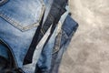 A stack of carelessly folded jeans on gray background. Closeup of jeans in different colors. Copy space. Selective focus Royalty Free Stock Photo