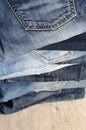A stack of carelessly folded jeans on wooden background. Closeup of jeans in different colors. Jeans texture. Copy space Royalty Free Stock Photo