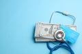 Stack of cash dollars and credit card with stethoscope on blue background. The concept of medical strechevka or expensive medicine Royalty Free Stock Photo