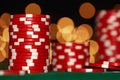Stack of casino chips on green table against bokeh background Royalty Free Stock Photo