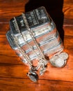 A stack of cast silver bars, various silver coins and jewelry on a background of mahogany