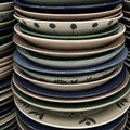 A stack of ceramic plates featuring various decorative patterns, predominantly in Royalty Free Stock Photo