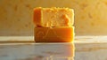 Stack of cheddar cheese blocks on marble surface reflecting warm light Royalty Free Stock Photo