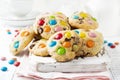 Stack of children cookies with colorful chocolate candies in a sugar glaze on a white light wooden background. Selective focus Royalty Free Stock Photo