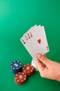 Stack of chips and hand with four aces Poker cloth a deck of cards poker hand and chips. Background Royalty Free Stock Photo