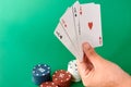 Stack of chips and hand with four aces Poker cloth a deck of cards poker hand and chips. Background Royalty Free Stock Photo