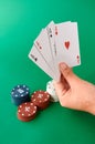 Stack of chips and hand with four aces, Poker cloth, a deck of cards, poker hand and chips. Background Royalty Free Stock Photo