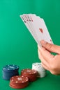 Stack of chips and hand with four aces, Poker cloth, a deck of cards, poker hand and chips. Background Royalty Free Stock Photo