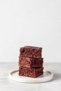 Stack of chocolate brownies on white plate on white background isolated. Delicious dessert, text space Royalty Free Stock Photo