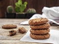 Stack of chocolate chip cookies on white napkin paper on wooden table