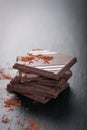 Stack of chocolate chunks on a dark stone background with cocoa Royalty Free Stock Photo