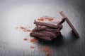 Stack of chocolate chunks on a dark stone background with cocoa, closeup Royalty Free Stock Photo