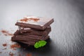 Stack of chocolate chunks with mint on a dark stone background with cocoa Royalty Free Stock Photo