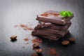 Stack of chocolate chunks with mint on a dark stone background with cocoa, closeup Royalty Free Stock Photo