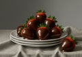 A stack of chocolate-covered strawberries is displayed on three white plates. The Royalty Free Stock Photo