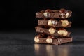 Stack of chocolate slices with mint leaf.Hazelnut and almond milk and dark chocolate pieces tower.Sweet food photo concept. The Royalty Free Stock Photo