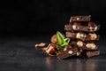 Stack of chocolate slices with mint leaf.Hazelnut and almond milk and dark chocolate pieces tower.Sweet food photo concept. The Royalty Free Stock Photo