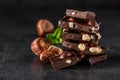 Stack of chocolate slices with mint leaf.Hazelnut and almond milk and dark chocolate pieces tower.Sweet food photo concept. The Royalty Free Stock Photo