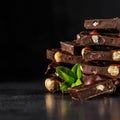 Stack of chocolate slices with mint leaf.Hazelnut and almond milk and dark chocolate pieces tower.Sweet food photo concept. The Royalty Free Stock Photo