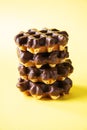 Stack of chocolate waffles. Close up and yellow background, copy space