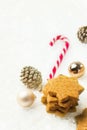 Stack of Christmas shortbread cookies with hazelnuts in star shape golden balls pine cones candy cane on snowy background. Holiday Royalty Free Stock Photo