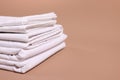 Stack of clean bed linens on beige background, closeup. Space for text Royalty Free Stock Photo