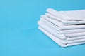 Stack of clean bed linens on light blue background, closeup. Space for text Royalty Free Stock Photo