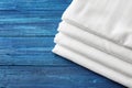 Stack of clean bed sheets on color wooden background Royalty Free Stock Photo