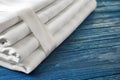 Stack of clean bed sheets on color wooden background, closeup Royalty Free Stock Photo