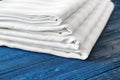 Stack of clean bed sheets on color wooden background, closeup Royalty Free Stock Photo