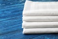 Stack of clean bed sheets on color wooden background, closeup Royalty Free Stock Photo