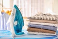 Stack of clean clothes and iron on board Royalty Free Stock Photo