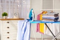 Stack of clean clothes and iron on board Royalty Free Stock Photo