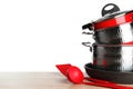 Stack of clean cookware and utensils on table against white background Royalty Free Stock Photo