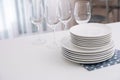 Stack of clean dishes and glasses on table in kitchen Royalty Free Stock Photo